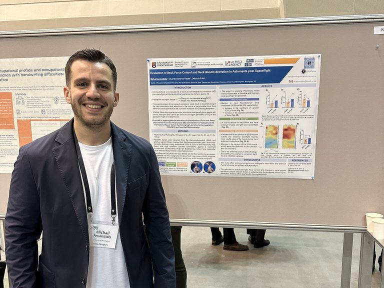 Michail Arvanitidis beside his poster on neck force control in astronauts